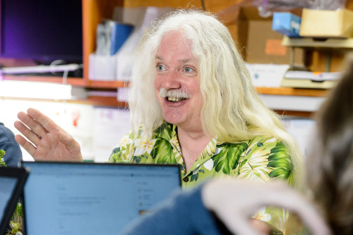 Photo of Simon Gilroy speaking and smiling in a lab setting.