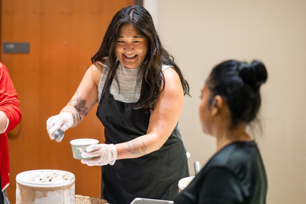 A woman scoops ice cream.