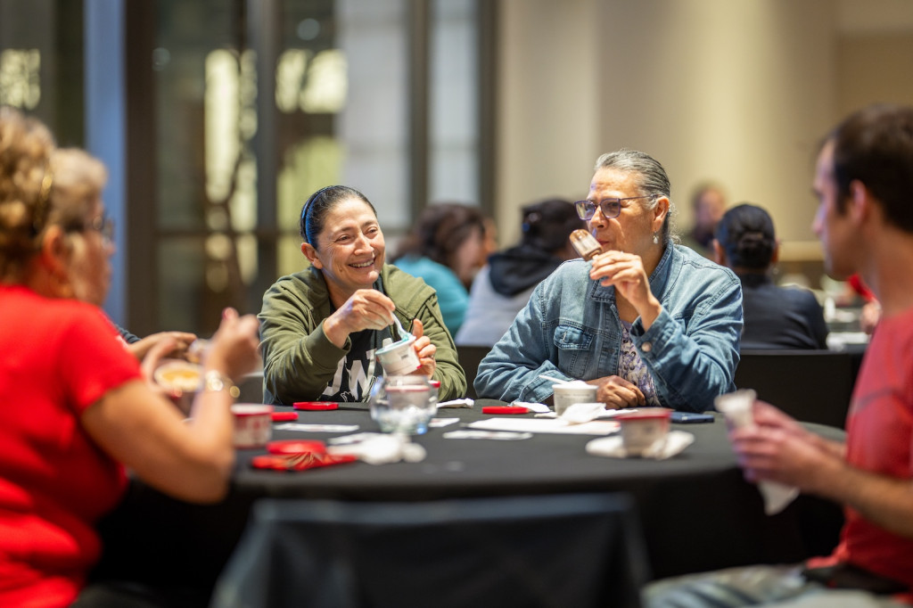 People gather around a table and enjoy ice cream.