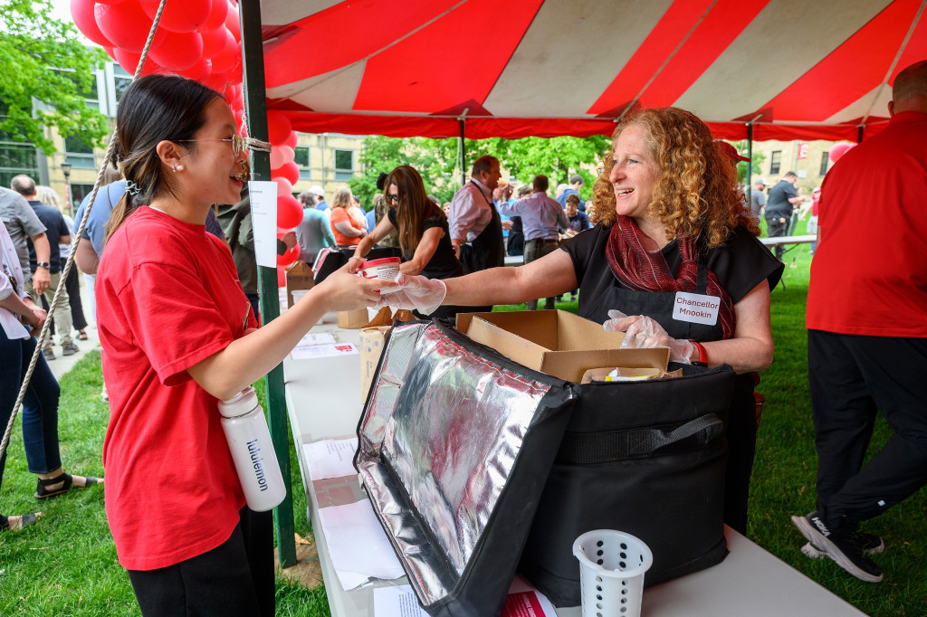 A woman hands out ice cream.