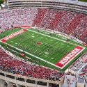 An aerial photo of Camp Randall football stadium with the stands filled with fans wearing red and white.