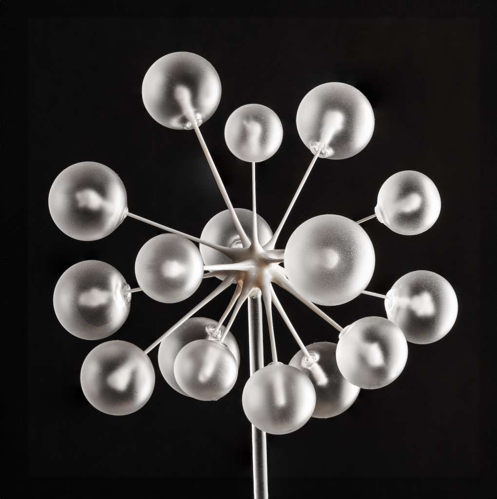 A number of round clear balls are attached to a stem.