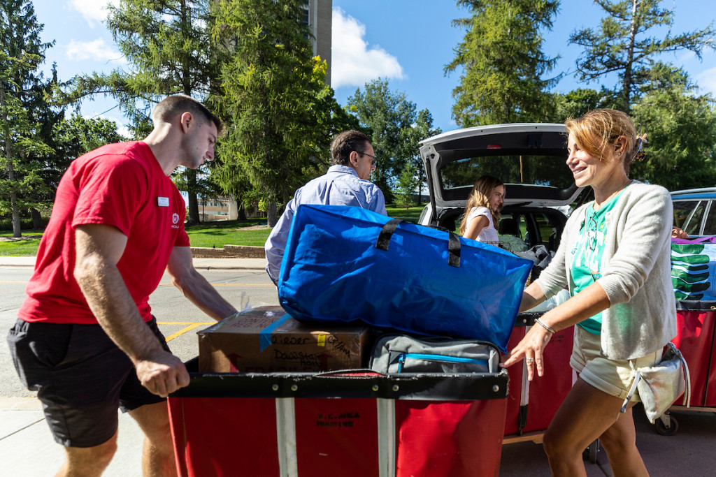 A travel bag and other personal items are stacked on a moving truck.