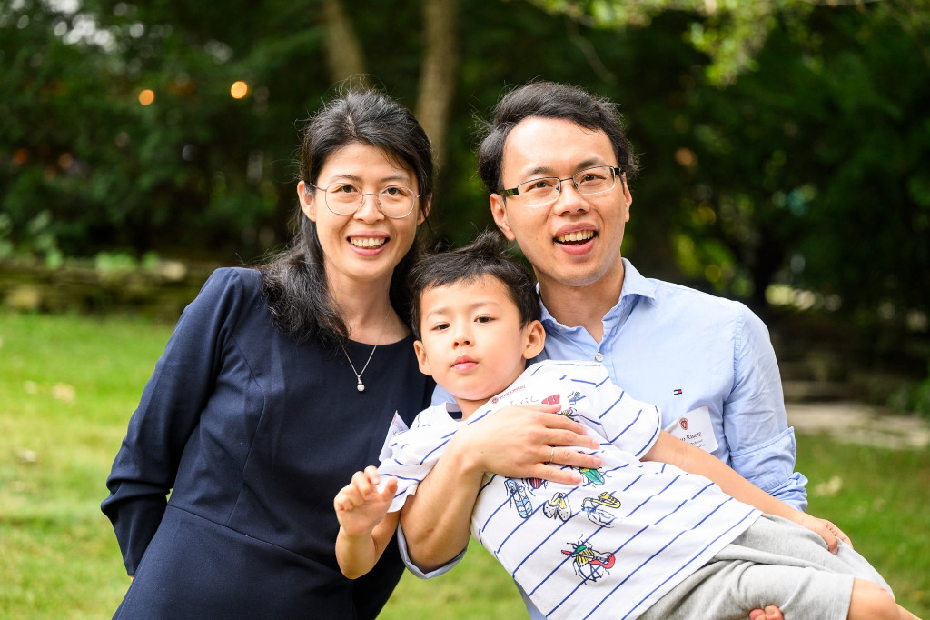 A man and woman and their son pose for a photo, smiling.