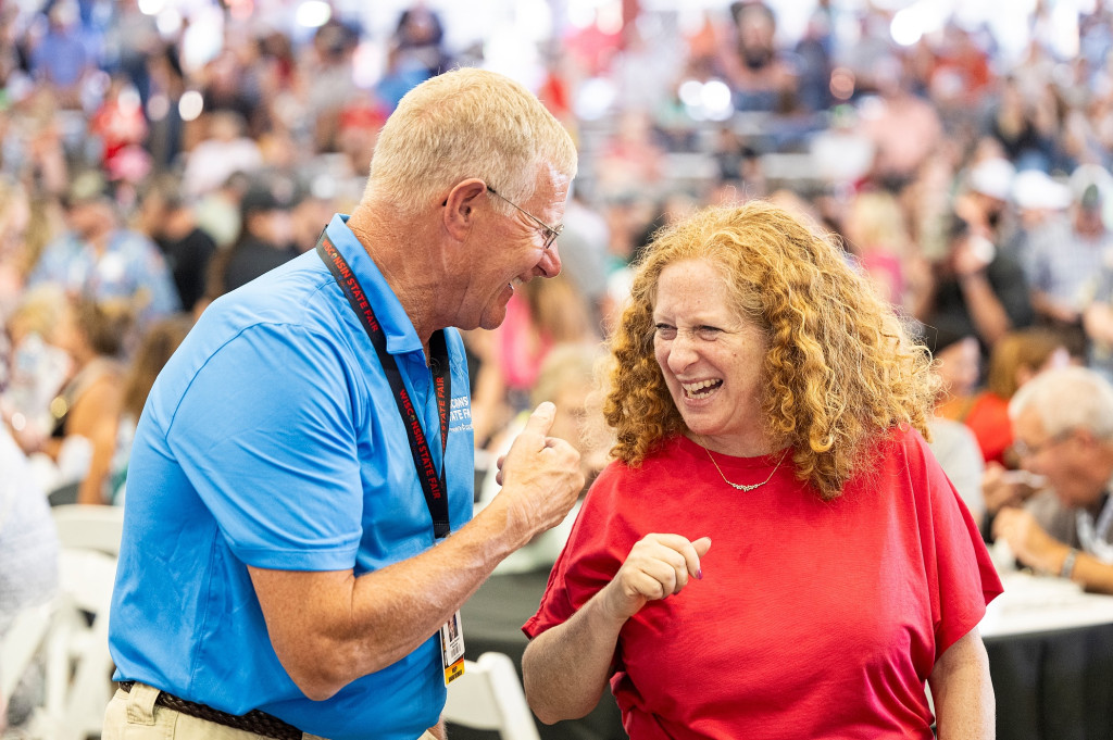 Two people lean in with smiles while exchanging laughs.