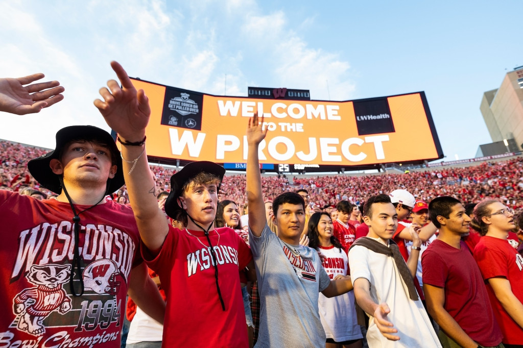 Students sing "Varsity" and wave their hands.