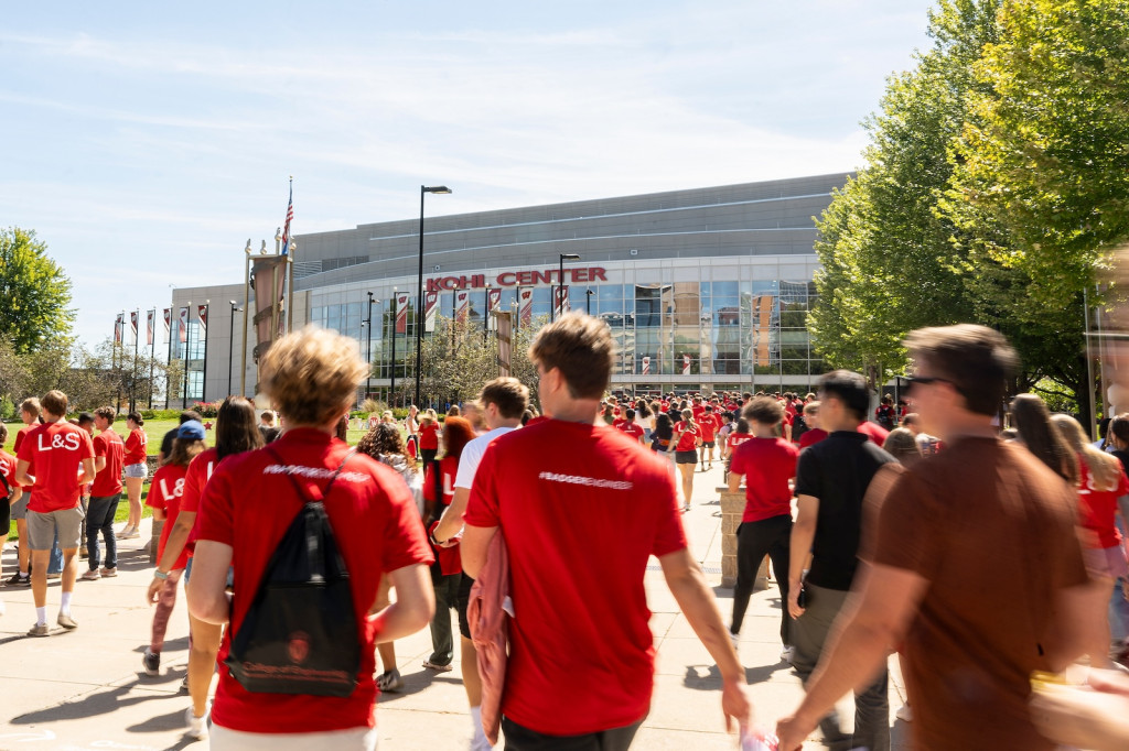 People walk toward an arena.