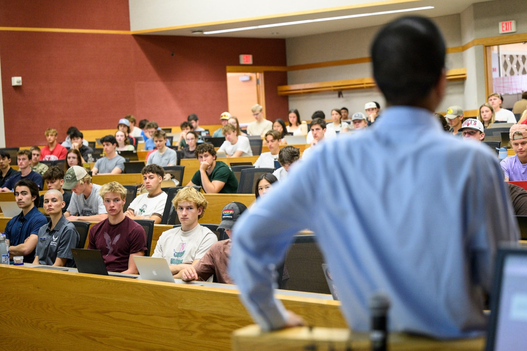 A man stands facing a crowded classroom.