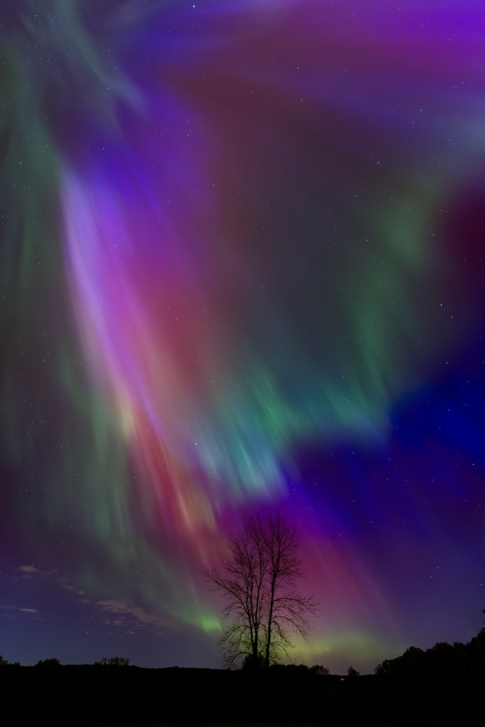 Waves of colorful light rays fill a dark background.