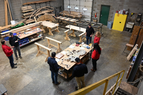 Two people work in a wood shop.