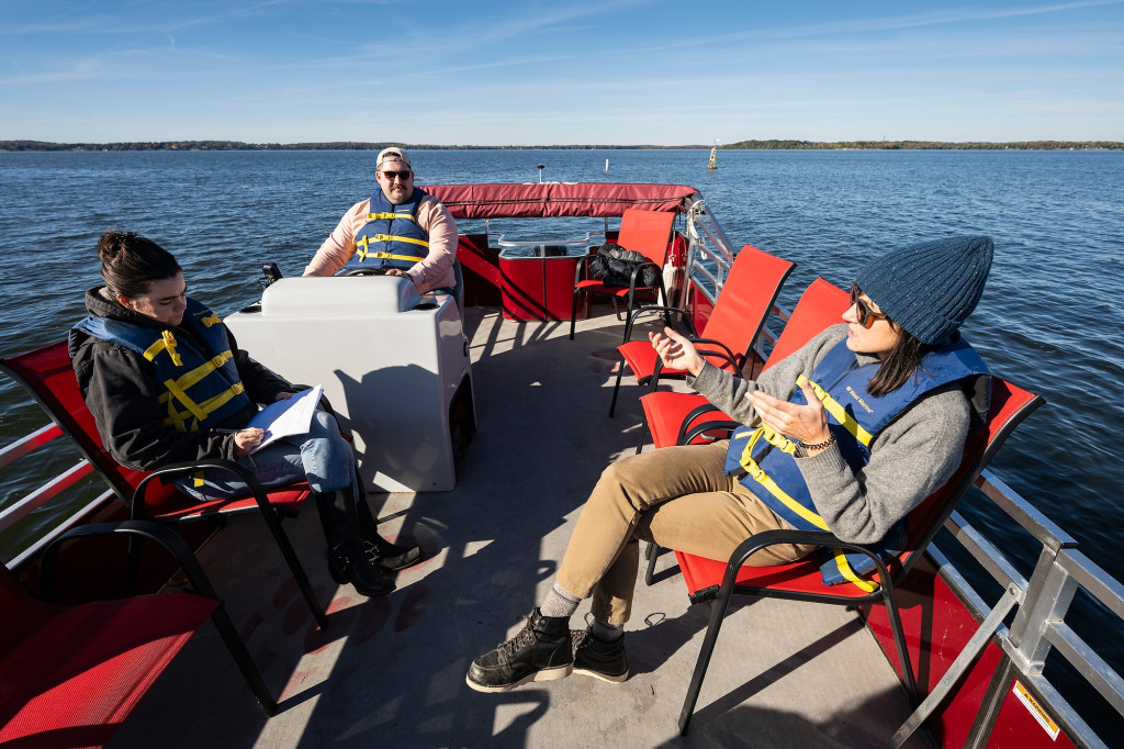 Several people are sitting in a pontoon boat.