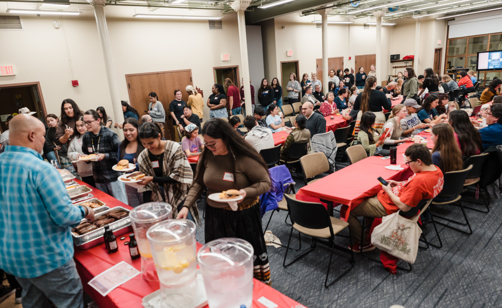 A crowd forms a line for food.