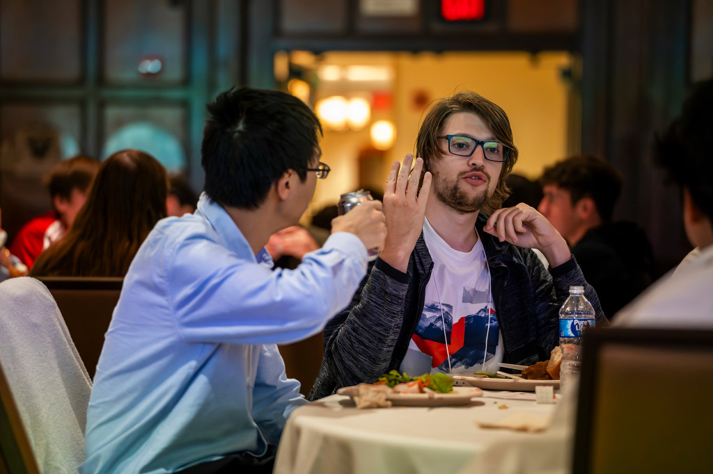 People sitting around a table eat and talk.