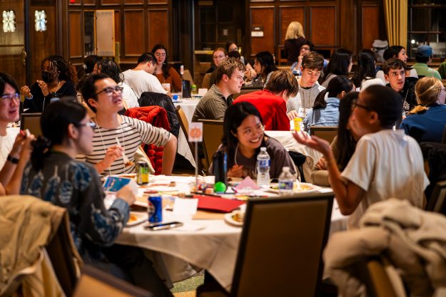 People sitting around a table eat and talk.