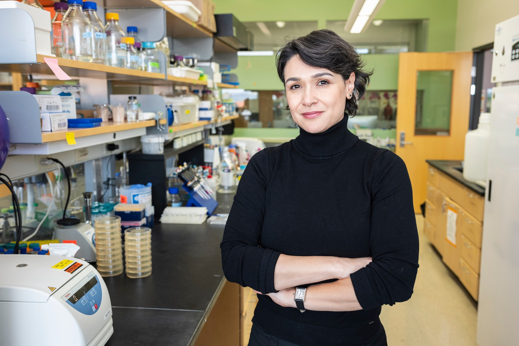 A woman stands in a laboratory setting.