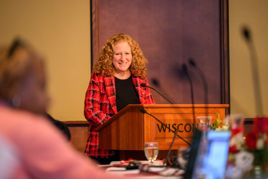 A woman stands at a podium and speaks.