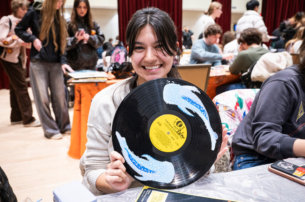 A student shows off a record painted with fish.