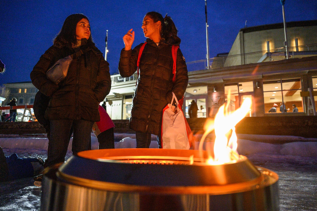 People gather around a bonfire on a frozen lake on a winter's night.