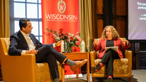 Two people talk on a stage.