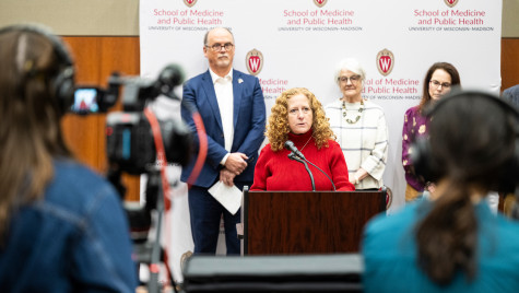 Chancellor Mnookin sands behind a podium addressing media.