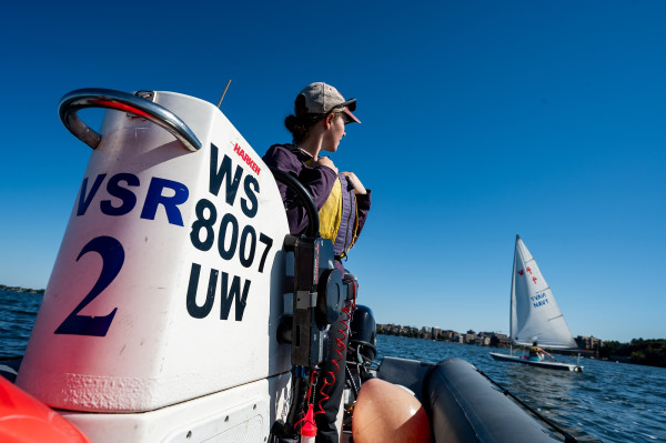 A woman operates a motorboat on the water.