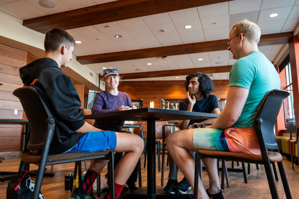 Four people sit around a table, smiling and talking.
