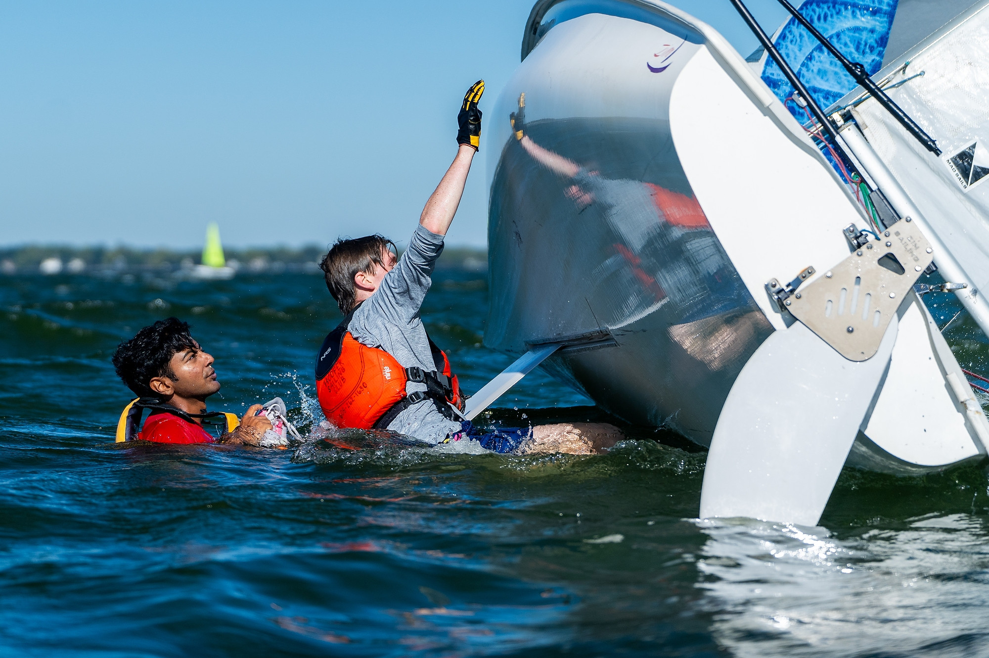 Two people set a boat upright.