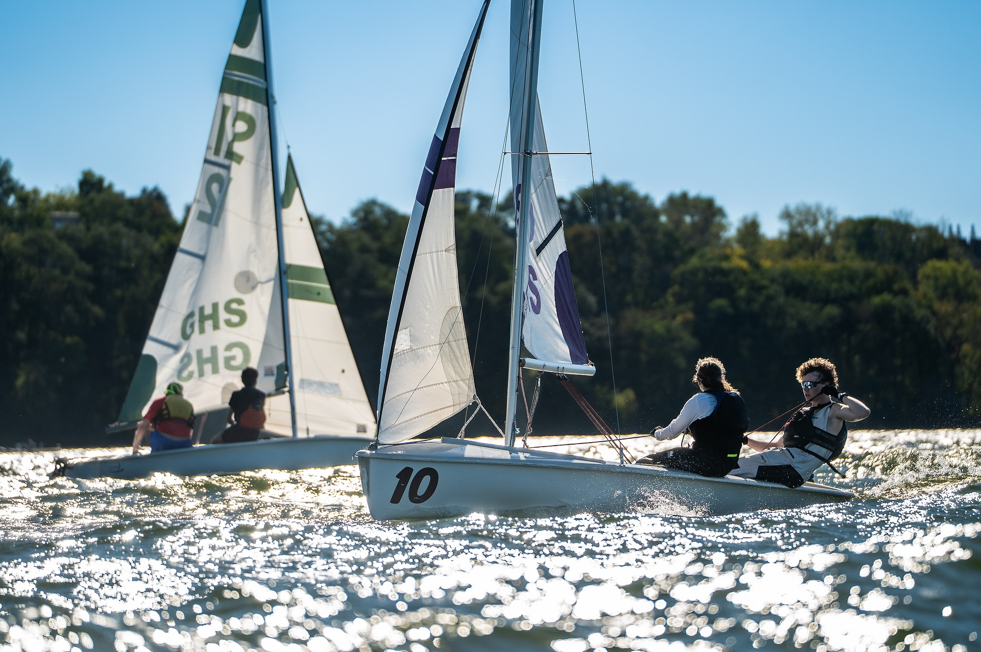 Two sailboats race in the water.