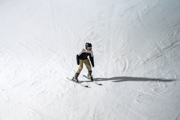 A person skis on a snow-covered slope.