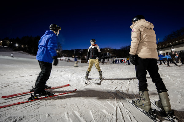 A person skis toward two other people.