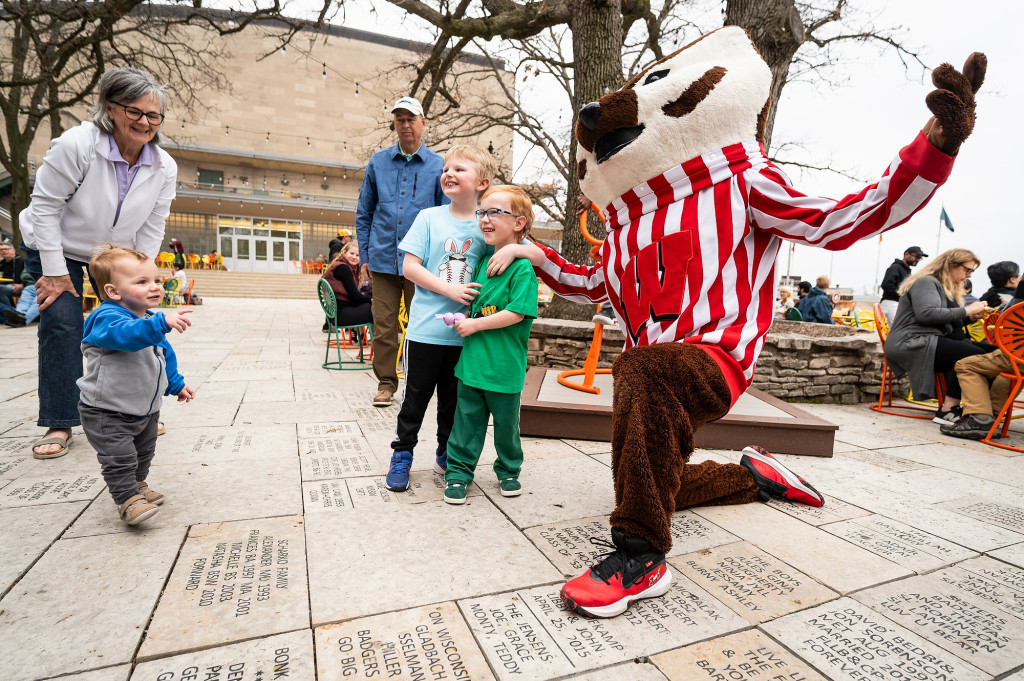 Children pose for a photo with UW–Madison mascot Bucky Badger during a Terrace chair return party.