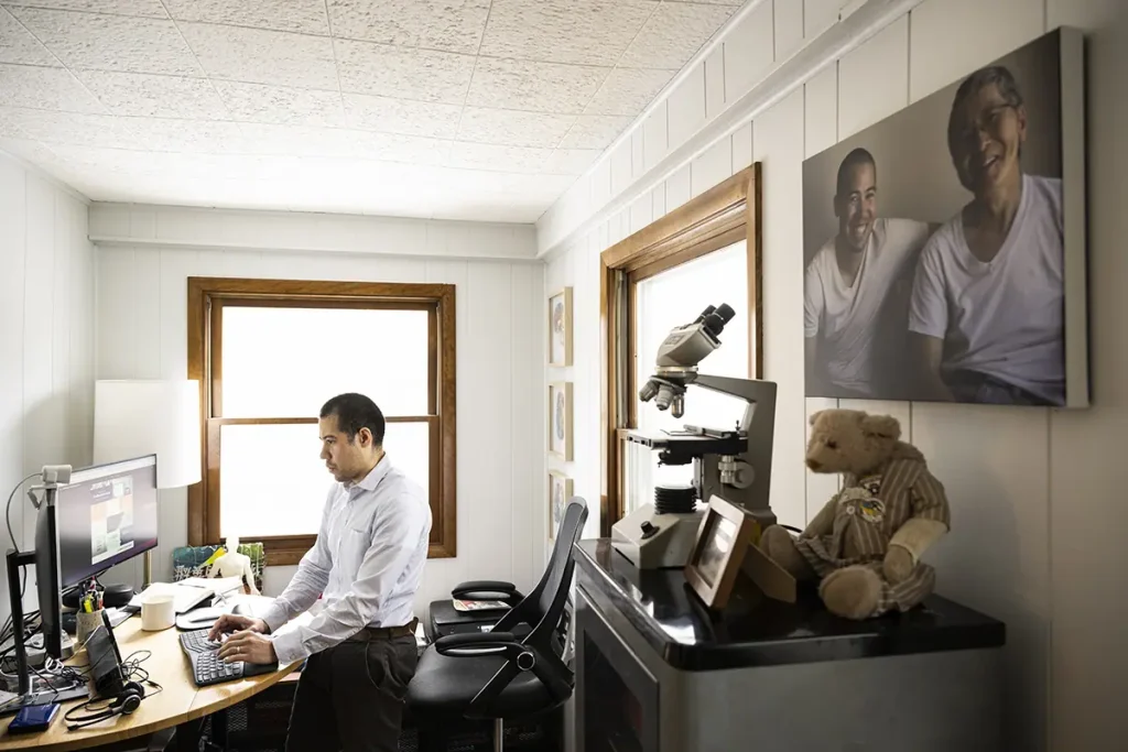 Nate Chin works at a computer in his home office, with keepsakes from his father nearby.
