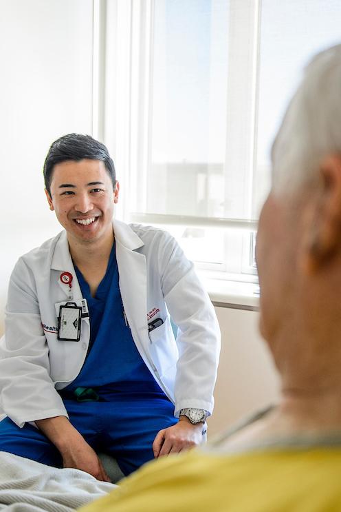 A patient and heal care worker are sitting facing each other in a clinic setting