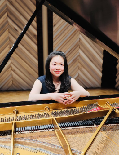 A woman is pictured at a piano.