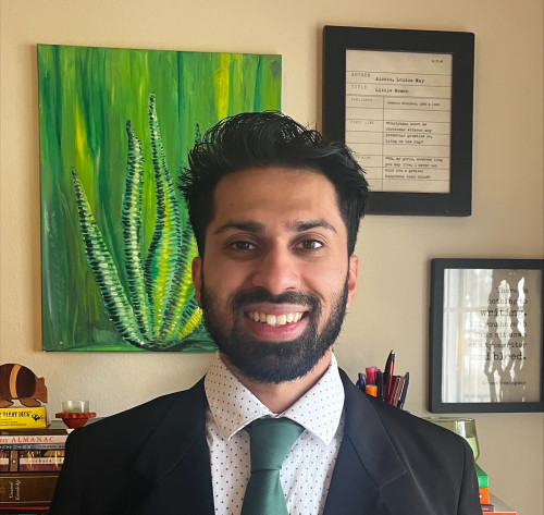 Avenash Pernankil smiles for a photo taken in an office setting