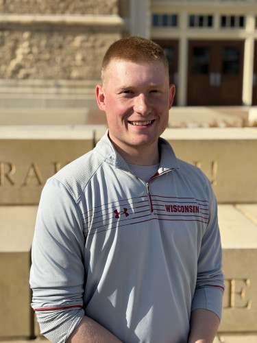 Portrait photo of Brock Prough standing outside in front of a Camp Randall stadium