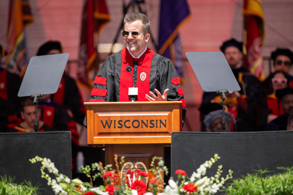 Jason Gay speaks to graduates from a podium.