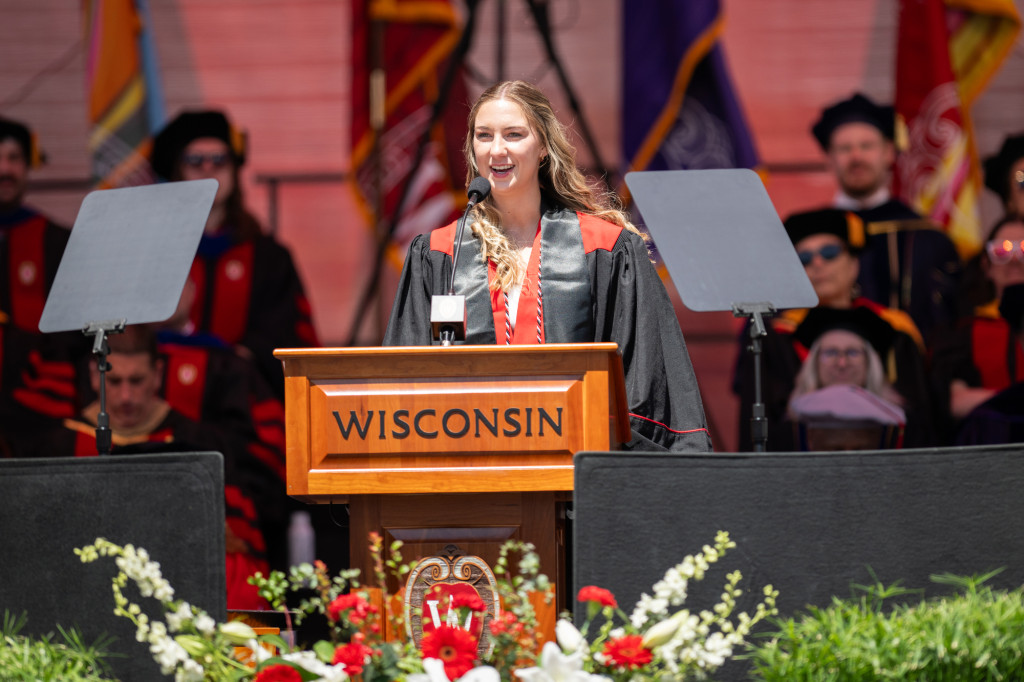 A woman speaks at a podium on a stage.