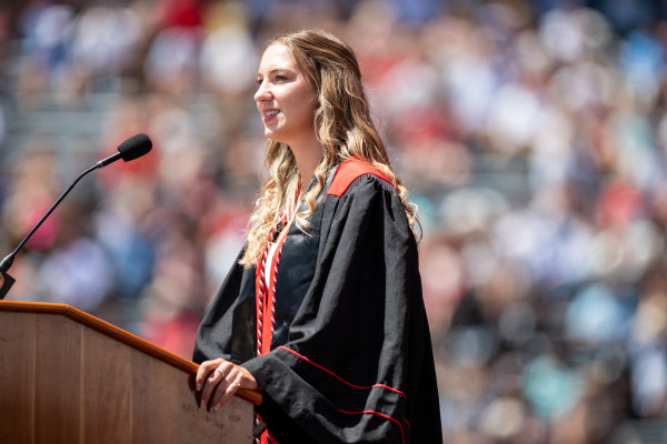 Sam Mahlum stands at a podium and looks out as she speaks to a crowd.