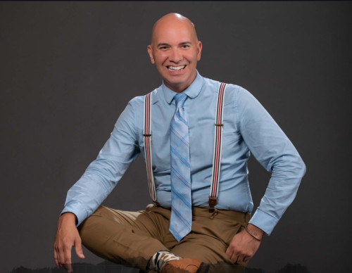 Daniel Schuyler smiles and sits for a studio portrait photo
