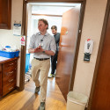 Hoffman walks into a treatment room at Aurora Medical Center–Manitowoc County followed closely by Leiknes whose hand remains on the door of the treatment room as he pulls it shut. As they enter, they are greeted by dimmer lights and a computer that partially shows x-rays of an unidentified patient.