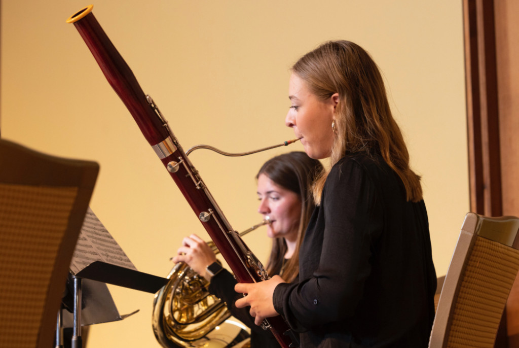 A woman plays a bassoon.