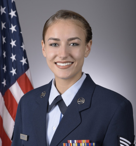 Service photo of Mira Tcherneva in uniform in front of a U.S. flag
