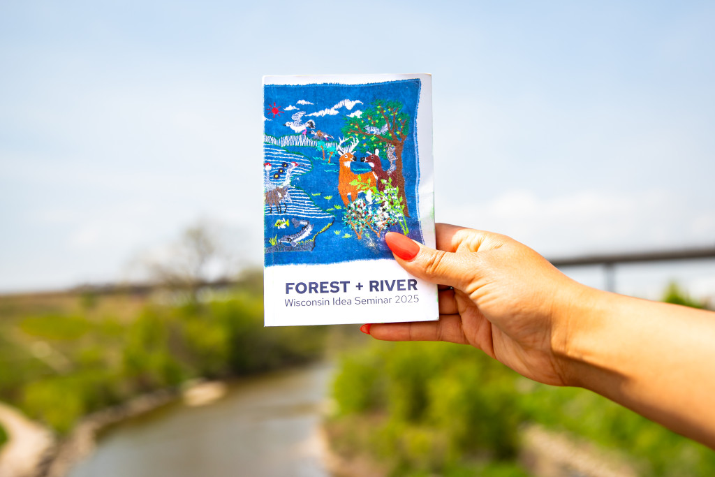 A hand holds a colorful booklet.
