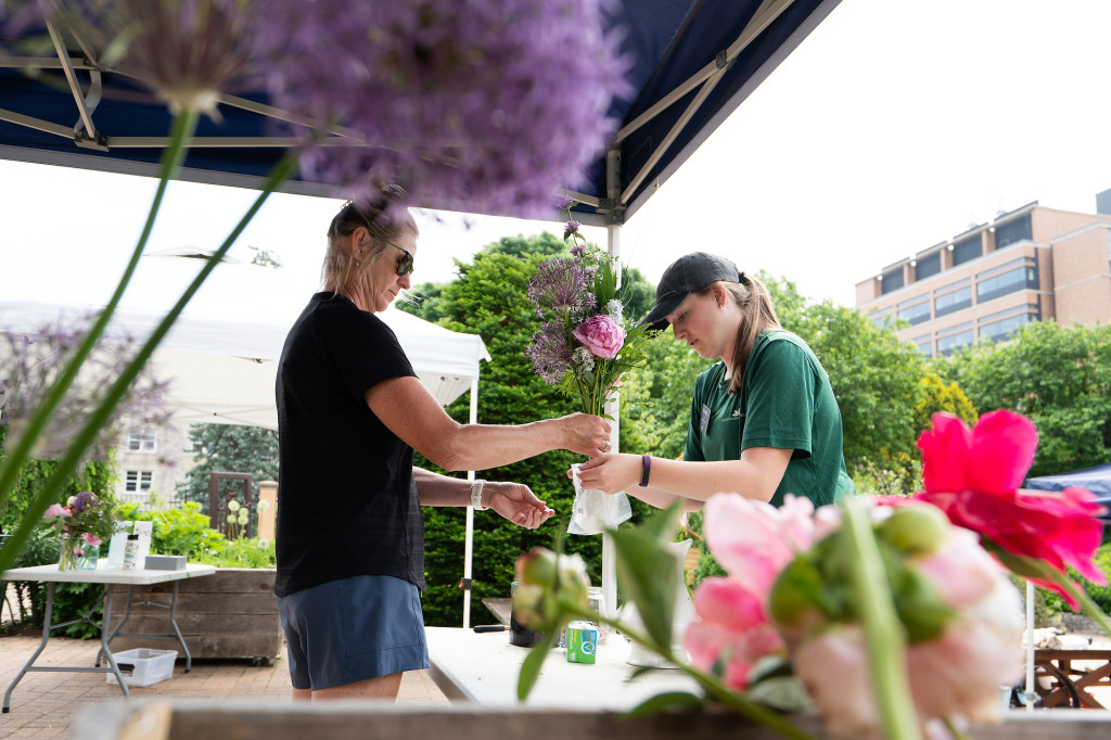 A person hands out flowers to another person.