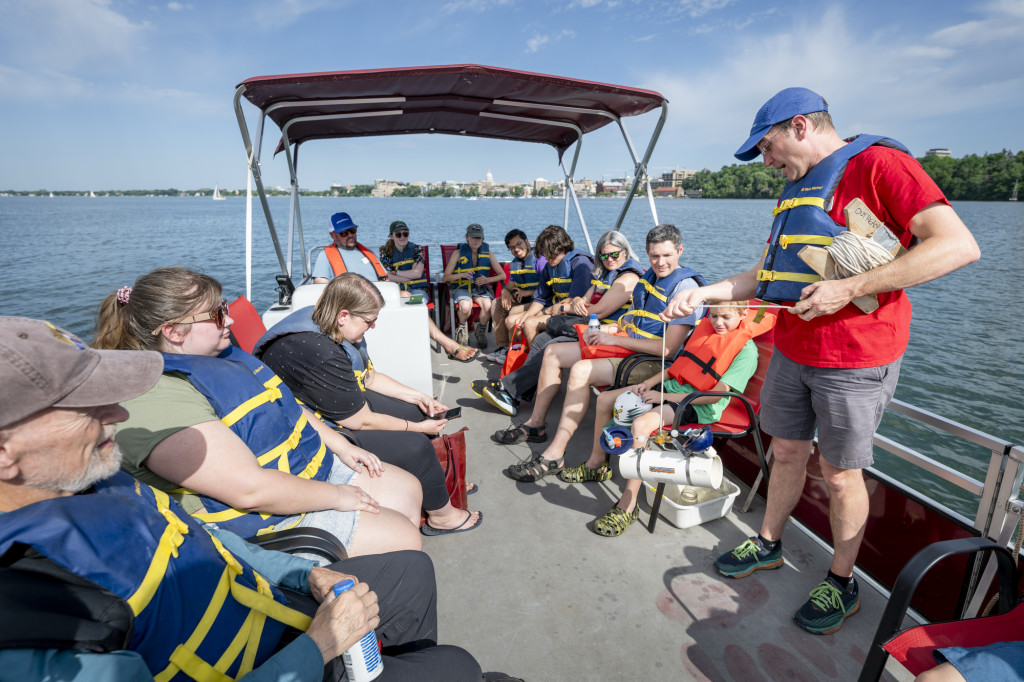 A man talks to a boatful of people.