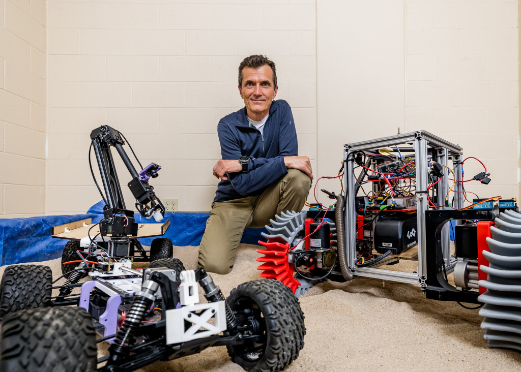 A man is shown with a space rover.