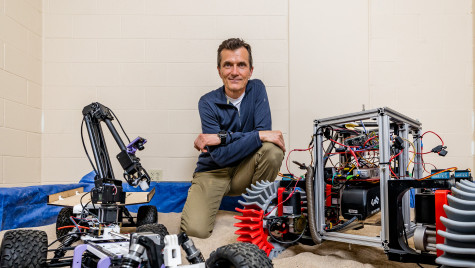 A man is shown with a space rover.