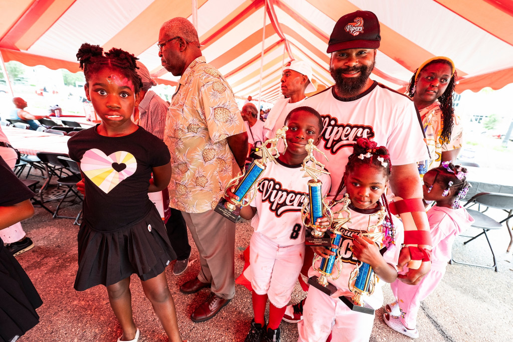 Hayes poses with his children who stand in front of and next to him under the big red and white tent.