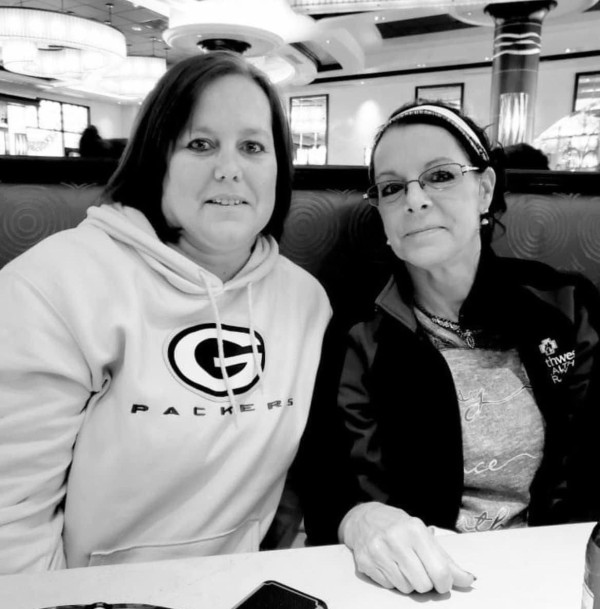 Grayscale photo of Barb Okey and Brenda Quale sitting together in a booth.
